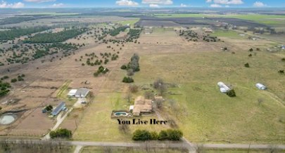 Aerial view of Trinity Ranch Inn and surrounding pastureland